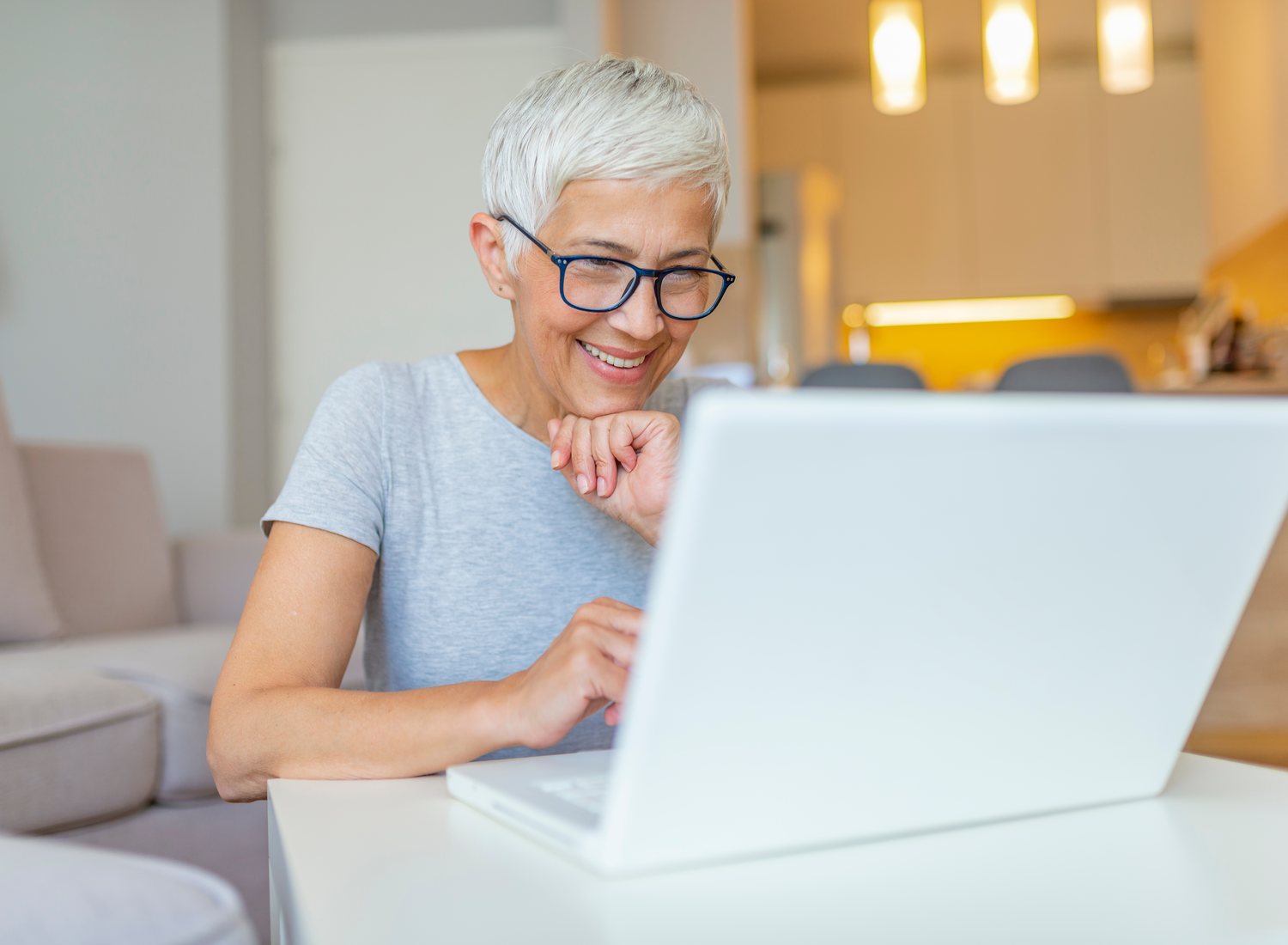 Usměvavá žena u notebooku při online webináři