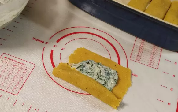 Na každý čtvereček těstovin rozetřeme špenátovou směs a zabalíme do trubičky.