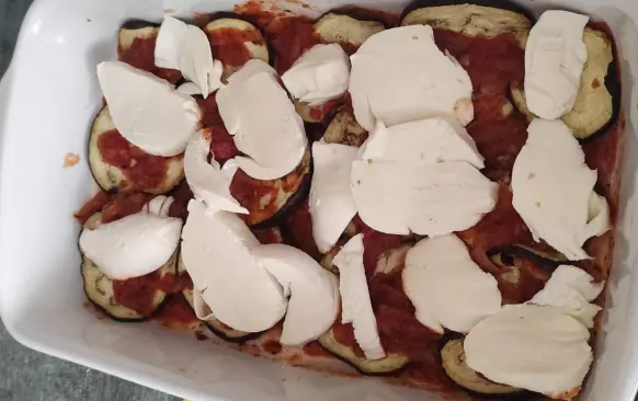 1. Lilek si nakrájame na tenké plátky, rozložíme, posolíme a odložíme bokom ''vypotit'' na 30 min

2. Nakrájame cibuľu a dáme osmazit na sadlo, pridáme sterilizované rajcata, ak sú v celku len rozmačkame vidličkou

3. pridáme strúžky cesnaku v celku a varíme, až sa nám všetko prevari , vyberieme cesnak a pridáme nasekanú bazalku, už nevaríme. Ak je omáčka príliš kysela pridáme čekankovy sirup 

4. Lilek utrieme papierovou uterkou, rozložíme na pečuci papier a dame piecť do mäkka na 15min a 180°C

5. Do zapekacej misky ako prvu vrstvu dame trošku omáčky, potom like, na to mozzarellu nakrájanú na kolieska alebo natrhanu, (bez vody), ďalšia vrstva omáčka a lilek, vrstvime podľa seba posledná vrstva však musí byť omáčka a tu zasypeme parmezánom

6. Pečieme 20min na 180°C, necháme chvíľu odležať a podávame 

7. Originál italsky recept samospráva s cesnakovym pečivom 

8. Dobrú chuť