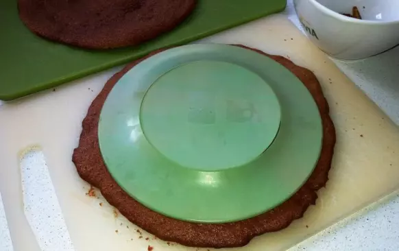 Po upečení vyjměte z trouby, chvíli nechte zchládnout a opatrně podeberte obracečkou. Sloupněte z papíru a nechejte zcela vychladnout. Papír pak použijte klidně znovu na další placku.
Jakmile jsou placky vychladnuté, pomocí talíře obřežte opatrně rovnoměrná kolečka a odřezky nastrouhejte.