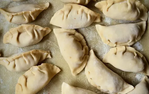 VYVALOVÁNÍ
Z mého pohledu nejjednodušší je použít strojek na těstoviny. Ne všichni ho ale budete mít, takže druhá nejjednodušší volba je vyválet velký plát a vykrajovat kolečkem nebo skleničkou. Velmi pravděpodobně se vám těsto nepodaří vyválet na relativně tenko (cca 1 mm), nic se ale nestresujte, vykrojte kolečko a pak před balením těsto vytahejte a vymačkejte ručně na tenčí plátek. Budete mít sice větší knedle, ale komu to va, ne?
