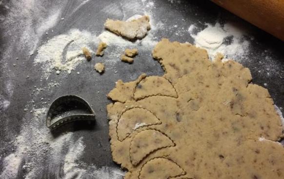 Do prosáté mouky přidáme citrónovou kůru,cukr,mandlovou mouku,rozsekané hrozinky,tlučený hřebíček a skořici. Těsto spojíme žloutky a máslem a vypracujeme.Necháme v lednici odležet (třeba přes noc). Vyválíme 3 mm silný plát a vykrojíme půlměsíčky.
Pečeme dorůžova. Pak je ještě teplé na plechu potřeme citrónovou polevou,kterou si umícháme z prosátého moučkového cukru a citrónové šťávy. 

Poznámky:
V původním receptu bylo 140 g cukru,já použila 100g. Na spojení surovin,byly uvedeny jen 2 vejce,směs byla sypká,tak jsem přidala 125 g másla. V původním receptu,se udělalo těsto a hned se vyválelo...já dala na noc odležet,ať se chutě a vůně krásně propojí.