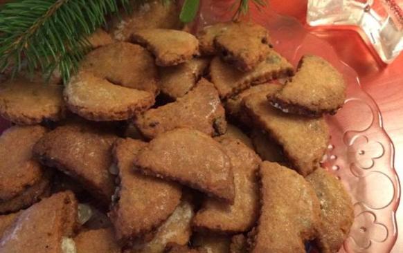 Do prosáté mouky přidáme citrónovou kůru,cukr,mandlovou mouku,rozsekané hrozinky,tlučený hřebíček a skořici. Těsto spojíme žloutky a máslem a vypracujeme.Necháme v lednici odležet (třeba přes noc). Vyválíme 3 mm silný plát a vykrojíme půlměsíčky.
Pečeme dorůžova. Pak je ještě teplé na plechu potřeme citrónovou polevou,kterou si umícháme z prosátého moučkového cukru a citrónové šťávy. 

Poznámky:
V původním receptu bylo 140 g cukru,já použila 100g. Na spojení surovin,byly uvedeny jen 2 vejce,směs byla sypká,tak jsem přidala 125 g másla. V původním receptu,se udělalo těsto a hned se vyválelo...já dala na noc odležet,ať se chutě a vůně krásně propojí.