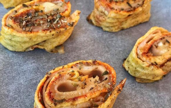 Na těsto natřeme rajčatový protlak, posypeme oregánem a vedle sebe poskládáme plátky šunky po celé ploše. Na šunku dáme sýr a zavineme do rolády. Do ní zapícháme párátka vedle sebe s menším rozestupem a nakrájíme kolečka. Ty pak skládáme vedle sebe na plech, potřeme rozšlehaným vajíčkem, posypeme oregánem a pečeme na 170 stupňů 15-20 minut. .