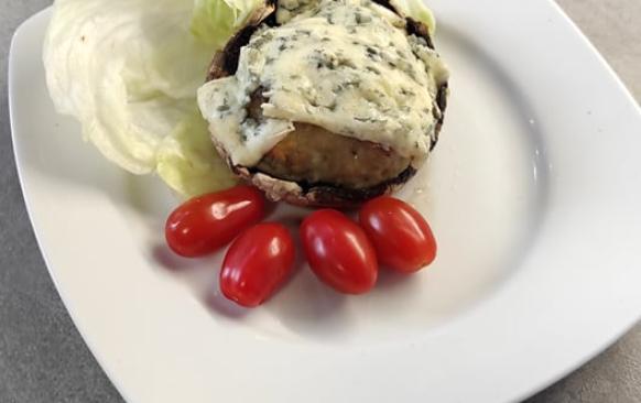 Nejdříve ulomte žampionům nožičky. Dejte na pánvičku rozehřát máslo, nakrájejte nožičky a cibulku. Orestujte to na rozehřátém másle. 
Do misky dejte kuřecí mleté maso, přidejte orestovanou cibulku a nožky ze žampionů., česnek, vejce a nastrouhaný sýr. Důkladně vše promícháme. Do pekáčku na pečící papír uděláme deset kusů karbanátků. Pečeme je při 150 stupních dvacet minut. 
Připravíme si další pekáček, kam připravíme  portobella. 
Upečené karbanátky položíme na portobella. Vršek pokryjeme tenoučkými plátky nivy. Dáme zapéct na deset minut na 150 stupňů. Zapečené portobello jsem servírovala se salátem z ledového salátu, chcerry rajčat a okurky. Salát  dochutila jsem balsamikovým